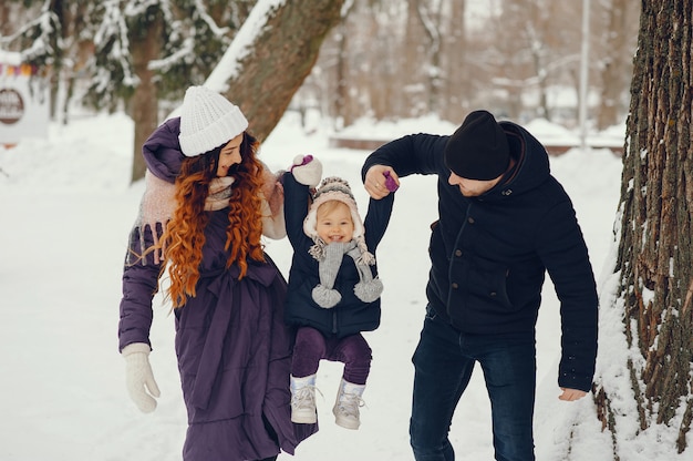 Bambina con i genitori in un parco di inverno