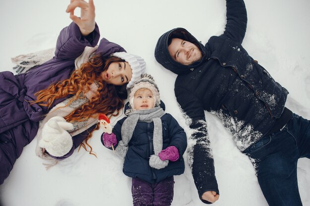 Bambina con i genitori in un parco di inverno