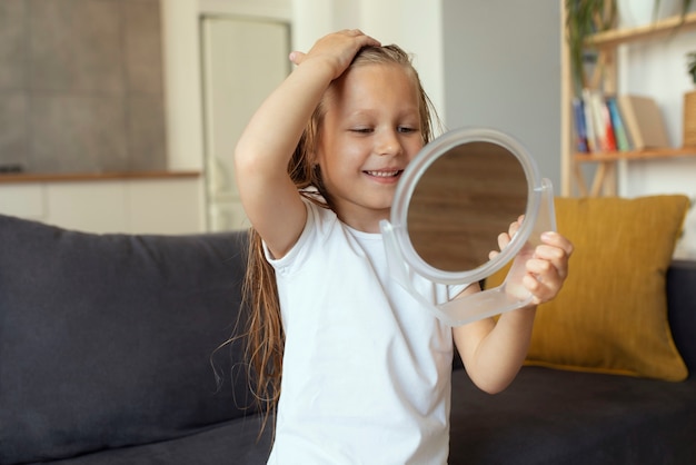 Bambina con i pidocchi che si prende cura dei suoi capelli