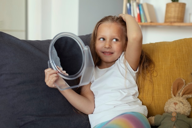 Bambina con i pidocchi che si prende cura dei suoi capelli