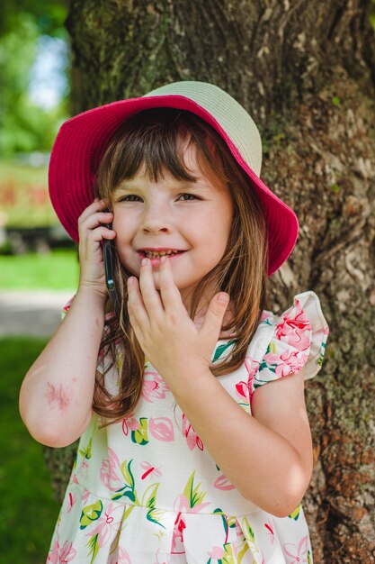 Bambina con il cappello rosa, parlando al telefono