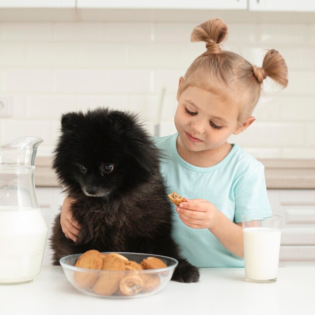 Bambina con il latte alimentare del cane