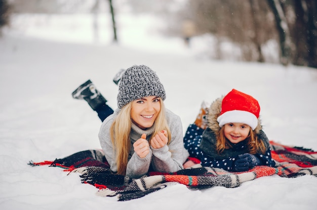 Bambina con la madre che gioca in un parco d'inverno