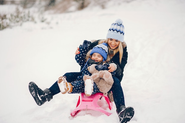 Bambina con la madre che gioca in un parco d'inverno