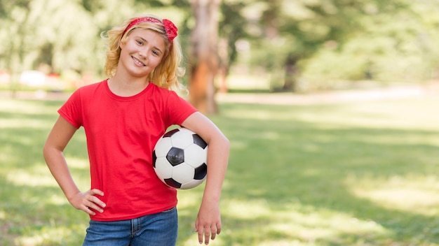 Bambina con pallone da calcio alla pari