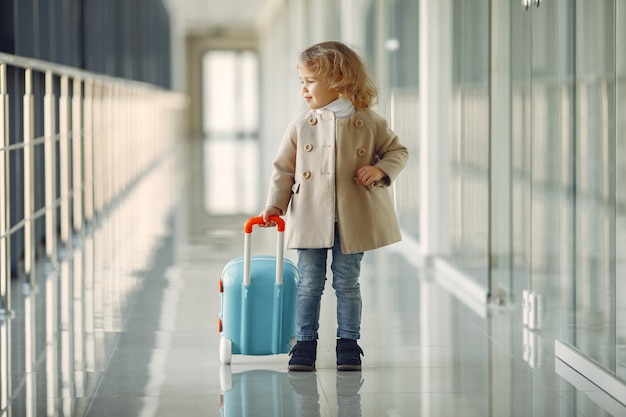 Bambina con una valigia in aeroporto