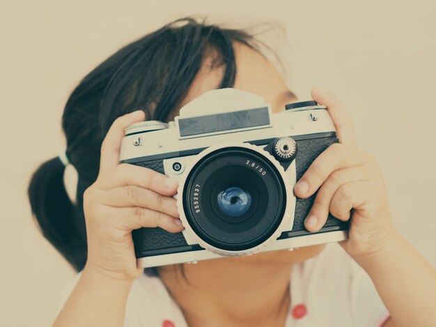 Bambina con una vecchia macchina fotografica