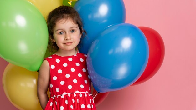 Bambina di smiley in un vestito rosso che celebra il suo compleanno
