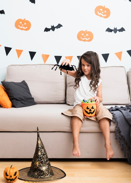 Bambina di vista frontale che si siede sullo strato su Halloween