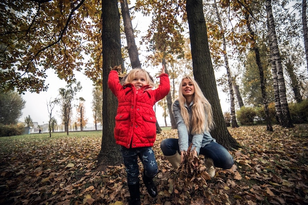 Bambina divertirsi con foglie secche