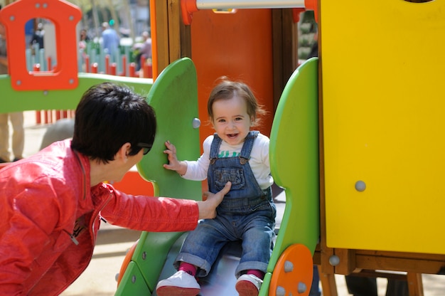 Bambina felice che gioca in un parco giochi urbano.