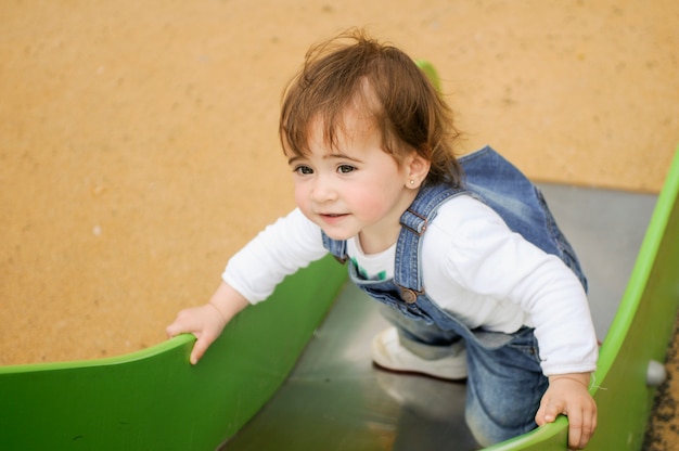 Bambina felice che gioca in un parco giochi urbano.