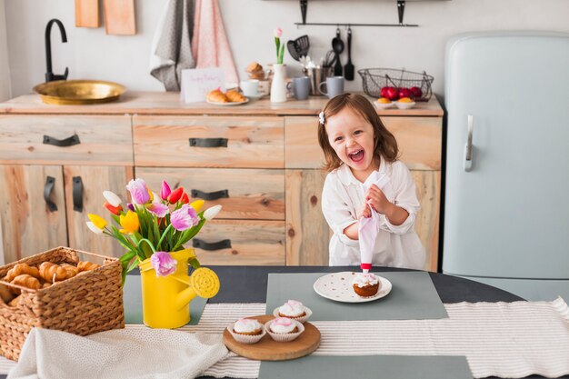Bambina felice facendo cupcake
