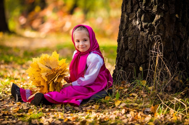 Bambina in costume di Masha dal cartone animato Masha e Orso sulla foresta d'autunno