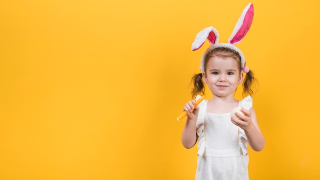 Bambina in orecchie da coniglio con penna uovo e feltro
