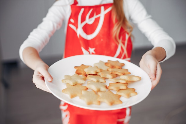 Bambina in piedi in una cucina con i biscotti