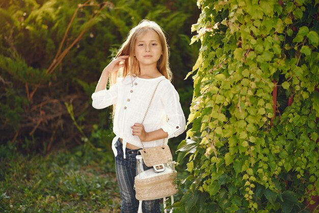 Bambina in un parco che sta con la borsa marrone