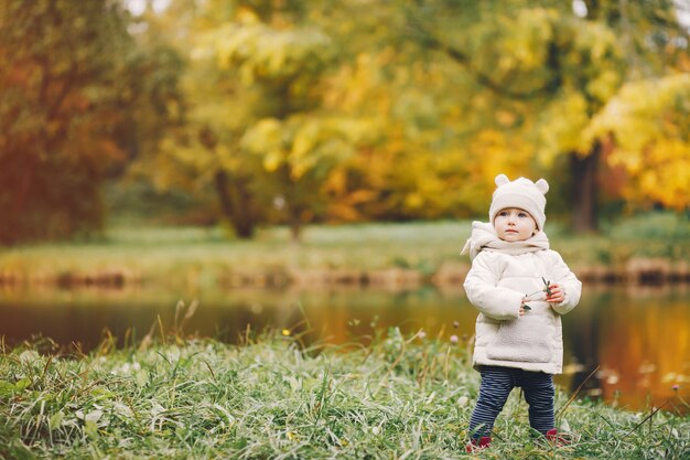 Bambina in un parco in autunno