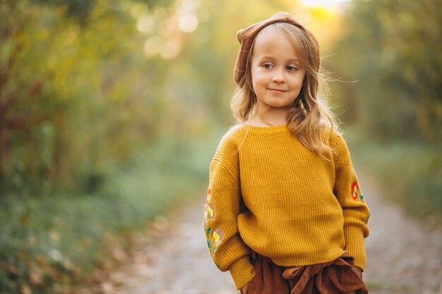 Bambina in un parco in autunno