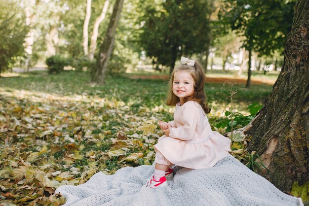 Bambina in un parco in un gioco di abiti rosa