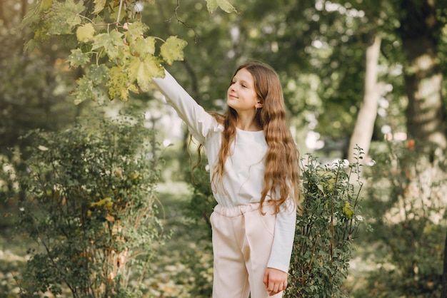 Bambina in un parco in una camicetta bianca