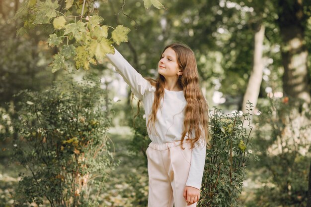 Bambina in un parco in una camicetta bianca