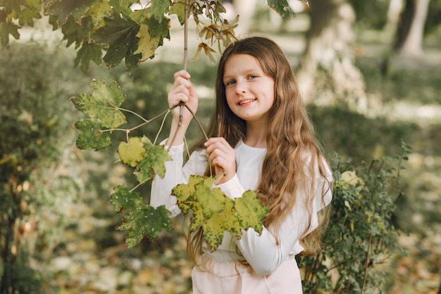 Bambina in un parco in una camicetta bianca