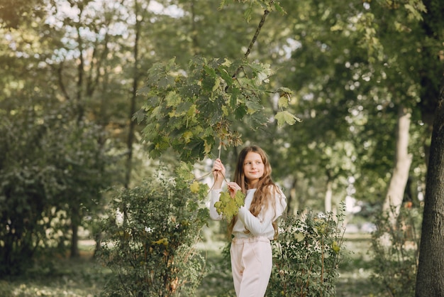 Bambina in un parco in una camicetta bianca