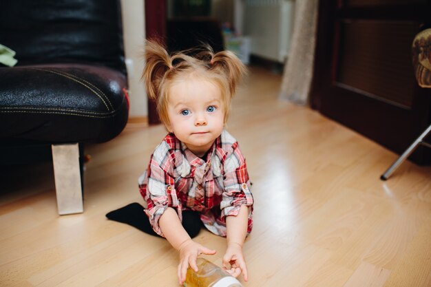 Bambina lasciando una bottiglia sul pavimento