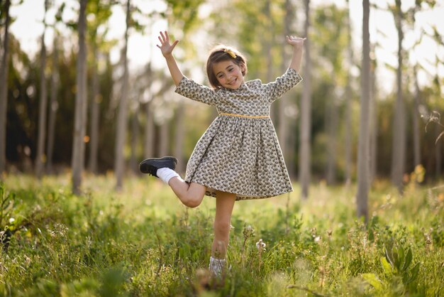 Bambina nel campo della natura che indossa un bel vestito
