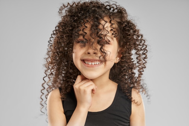 Bambina sorridente con i capelli ricci sul viso