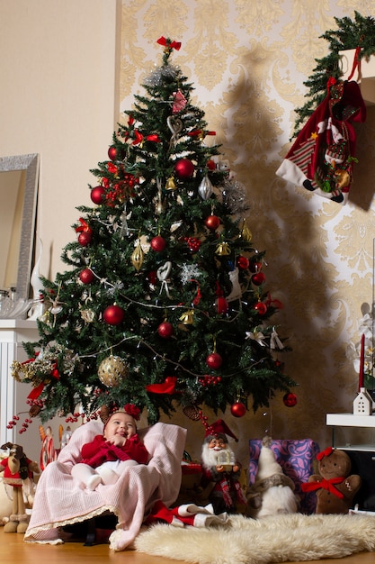 bambina sotto l'albero di natale con i giocattoli farciti