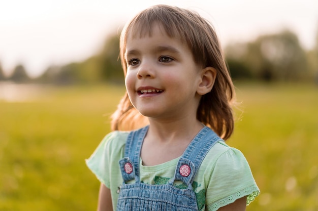 Bambina su un campo di tarassaco, al tramonto, bambino felice emotivo.