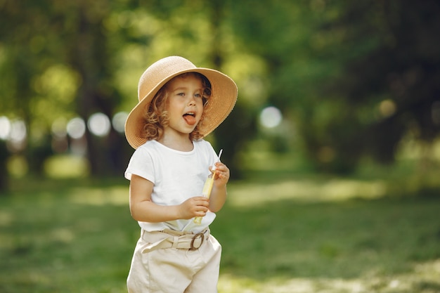 Bambina sveglia che gioca in un parco estivo