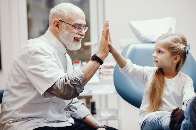 Bambina sveglia che si siede nell&#39;ufficio del dentista