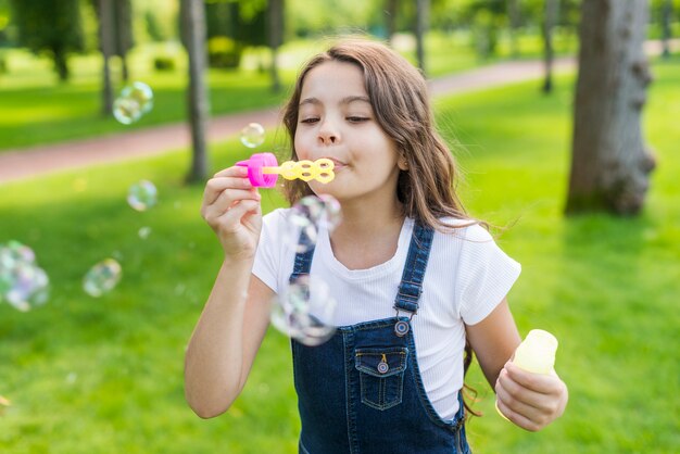 Bambina sveglia di vista frontale che fa le bolle di sapone