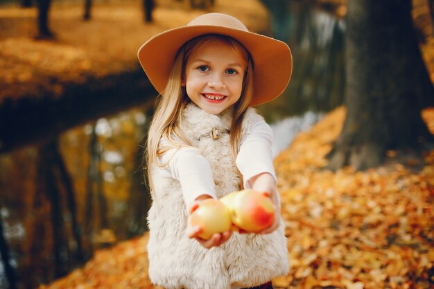 Bambina sveglia in un parco di autunno