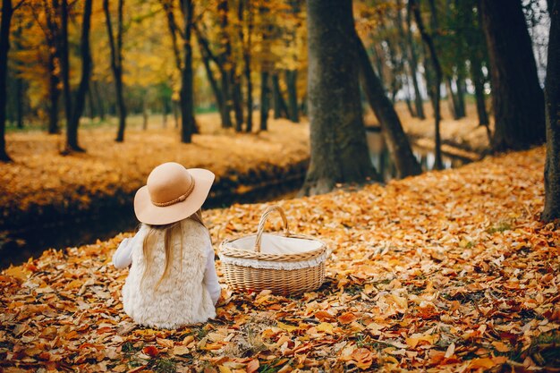 Bambina sveglia in un parco di autunno