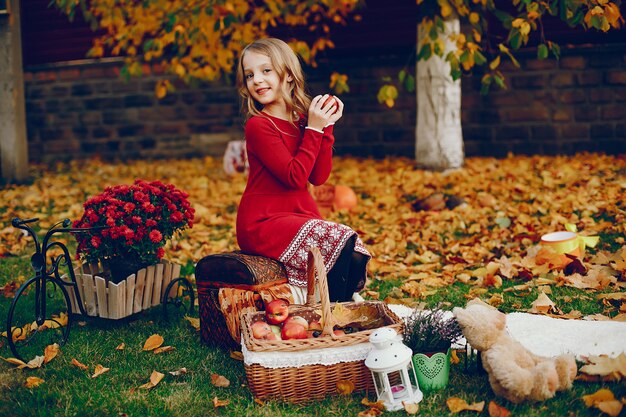 Bambina sveglia in un parco di autunno