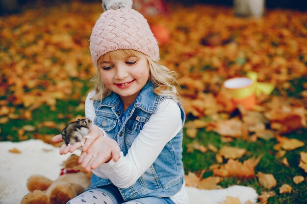 Bambina sveglia in un parco di autunno