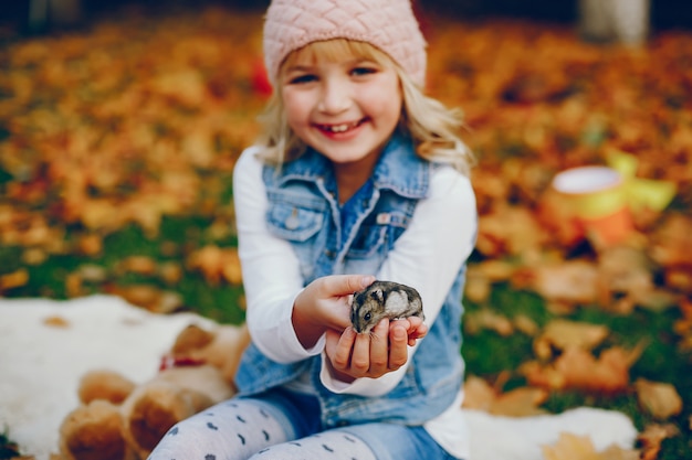 Bambina sveglia in un parco di autunno