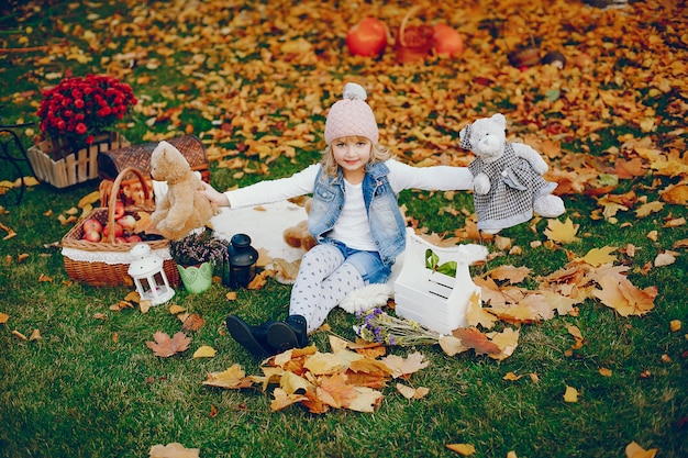 Bambina sveglia in un parco di autunno