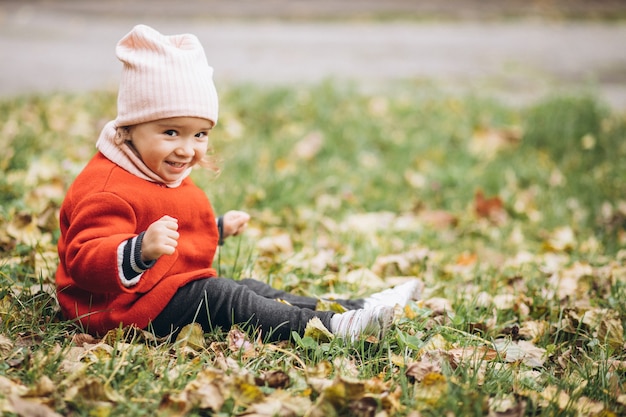 Bambina sveglia in un parco in autunno