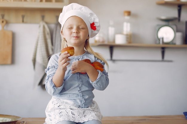 Bambina sveglia in una cucina con il bigné