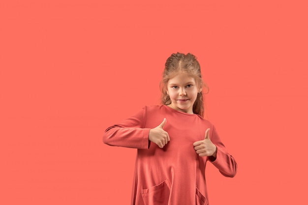 Bambina sveglia in vestito di corallo con sorridere dei capelli lunghi