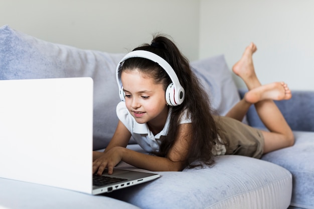 Bambine adorabili che utilizzano il suo computer portatile