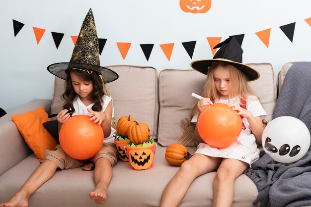 Bambine di vista frontale che si siedono sullo strato su Halloween