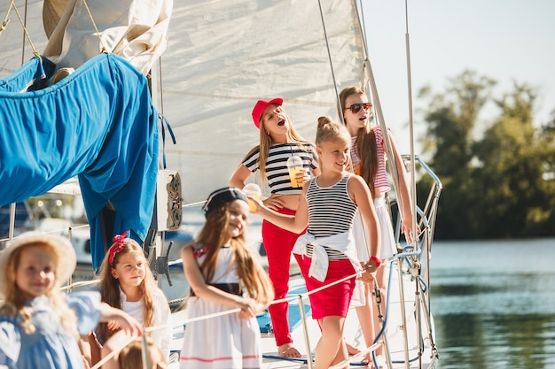 bambini a bordo di uno yacht del mare che bevono succo d'arancia.