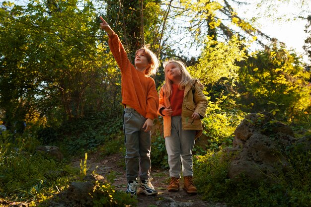 Bambini a figura intera che esplorano la natura insieme