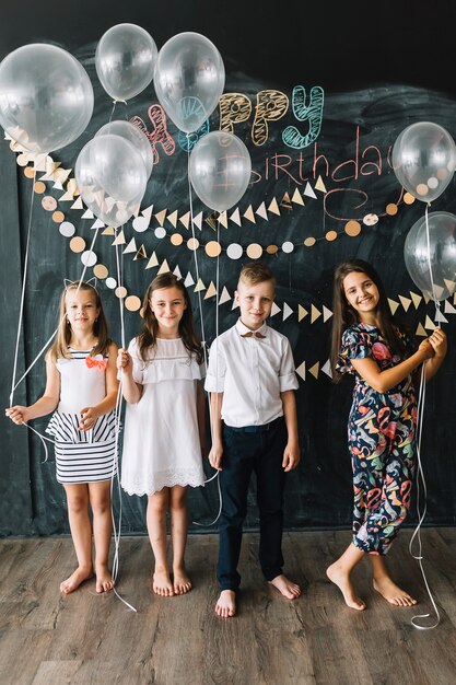 Bambini a piedi nudi con palloncini sulla festa di compleanno